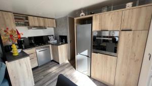 基伯龙Mobil home 3 chambres 40 m2的厨房配有木制橱柜和不锈钢用具