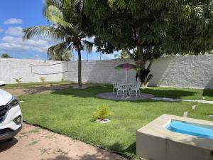 São Gonçalo do AmarantePousada MKC的一个带桌椅的庭院和一个游泳池