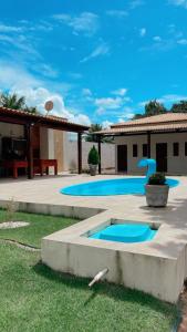 São Gonçalo do AmarantePousada MKC的后院设有2个游泳池和1座房子