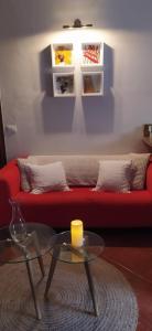 La GuanchaCasa Los Guanches的客厅配有红色的沙发和一张桌子上的蜡烛