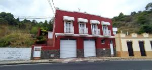 La GuanchaCasa Los Guanches的红楼,街上有两扇车库门