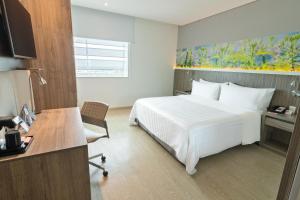 约帕尔约帕尔GHL风格酒店的一间酒店客房,配有一张白色的床和一张书桌