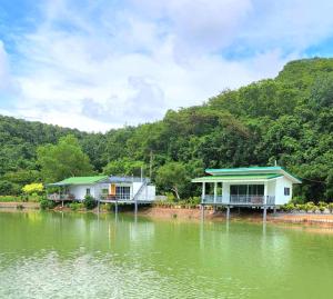 Ban Pang Chaphlungบังกะโลบ้านสวนเอก Bungalow Baan Suan Aek的两座房子坐在湖边