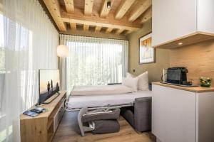 迈尔霍芬Natur Zeit - Alpine Garden Apartments的一间小卧室,配有床和窗户