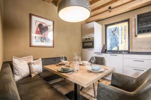 迈尔霍芬Natur Zeit - Alpine Garden Apartments的厨房以及带桌椅的用餐室。