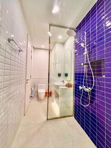 富国N&P Sunset Apartment Hillside Phú Quốc的浴室设有水槽和紫色瓷砖淋浴。
