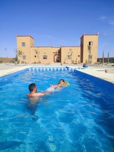梅尔祖卡Berber Palace Merzouga的男人和孩子在游泳池游泳