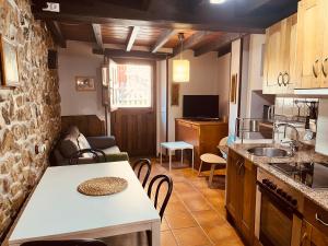 Las Rozas迭戈公寓的厨房以及带桌椅的起居室。