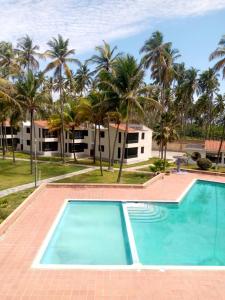 TucacasCosta Grande的棕榈树度假村前的游泳池