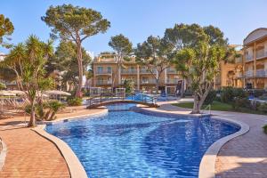 坎皮卡福特马略卡岛萨菲罗Spa公寓的一座拥有树木和建筑的度假村内的游泳池
