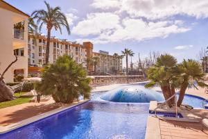 阿尔库迪亚港扎菲罗热带公寓的棕榈树和建筑的度假游泳池