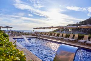 卡拉马奎达卡拉马奎达蓝宝石维瓦酒店的海滩上带椅子和遮阳伞的游泳池