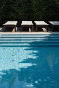 波尔图Marquês Garden House by Olivia的游泳池旁的两把长椅