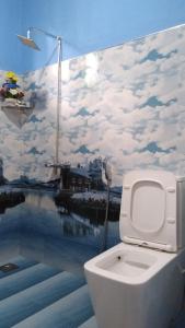 埃拉Holly House Homestay的浴室里的一个厕所,有云彩的壁画