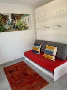 佩萨克Altéa的一间设有红色沙发、枕头和绘画的房间