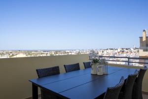 法鲁Miradouro da Penha的美景阳台配有蓝色的桌椅