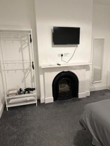 艾纯查姆5-Bed Apartment in Altrincham near airport的客房设有壁炉,墙上配有电视。
