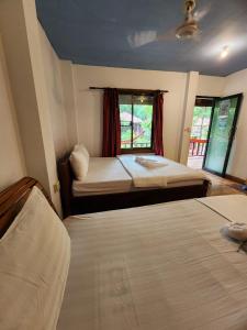 瓜隆岛Sweet Jungle Bungalows的一间卧室设有两张床和窗户。