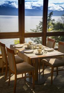 普孔Park Lake Luxury Hotel的餐桌、椅子和大窗户