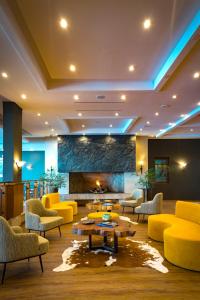 普孔Park Lake Luxury Hotel的大堂设有黄色家具和壁炉