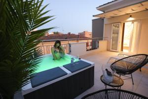 里米尼Hotel Cenisio的坐在阳台上热水浴缸中的女人
