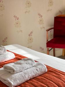 雷文斯通代尔肥羊乡村酒店及自然保护区的一张带毛巾和红色椅子的床
