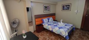 利马Aruba Suite Hotel的一间带一张床和风扇的小卧室