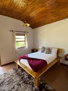 圣特雷莎Villaggio Zamprogno的一间卧室设有一张带木制天花板的大床