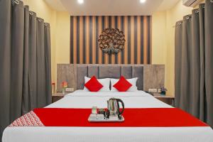 加尔各答Avenue Inn Near Birla Mandir的一间卧室配有一张带红色枕头的大床