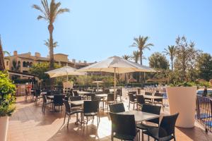 蒙特罗伊Pierre & Vacances Resort Bonavista de Bonmont的一间带桌椅和遮阳伞的餐厅