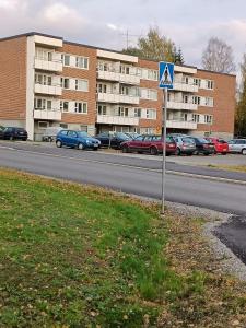 列克萨Kolmio Väinöläntie 6的停车场内有车辆的街道标志