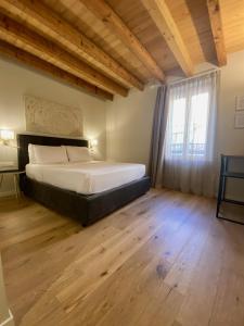 代森扎诺-德尔加达Malvezzi24 Boutique Rooms的一间卧室设有一张大床,铺有木地板