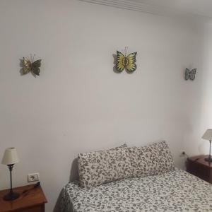 戈梅拉岛圣塞瓦斯蒂安JS crecer的床上方墙上有两只蝴蝶