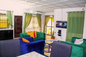 AgegeARO (1.0) 2BD Studio Flat (Abule-Egba/Lagos)的客厅配有五颜六色的椅子和桌子