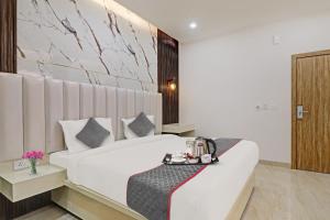 ChinhatSuper Townhouse 1149 Hotel Impact的酒店客房设有一张带桌子的大型白色床。