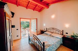 阿尔布斯Agriturismo Rocce Bianche - Porticato的一间卧室设有一张床和一个滑动玻璃门