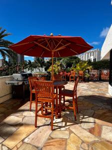 檀香山Luana Waikiki Park Views的露台的遮阳伞下的桌椅