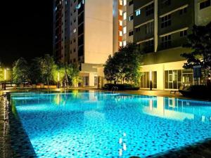 雪邦KLIA Homestay Apartment - 2 room的夜间蓝色海水的大型游泳池