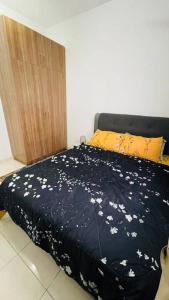 雪邦KLIA Homestay Apartment - 2 room的一张床上的黑色毯子,上面有白色的花朵