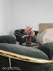RoşuRobik Studio Militari Residence的椅子上带花瓶的桌子