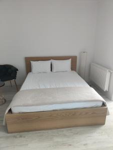 RoşuRobik Studio Militari Residence的一间卧室配有一张木架大床
