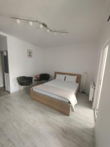 RoşuRobik Studio Militari Residence的白色卧室配有床和桌子