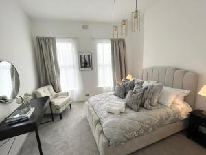 贝尔法斯特Luxury Belfast Stay - Townhouse的一间卧室配有一张床、一张桌子和一把椅子
