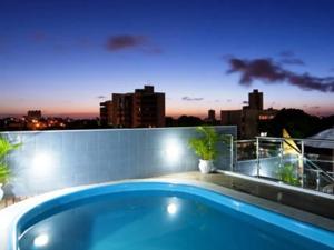 纳塔尔Hotel Agua Marinha的游泳池位于带城市天际线的阳台的顶部