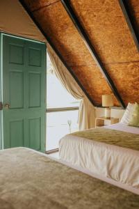 EscuintlaLos Olivos La Playa Hotel y Restaurante的一间卧室设有两张床和一扇绿门