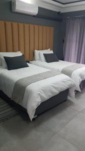伯格斯堡Honolulu Lifestyle Guest Lodge的卧室内两张并排的床