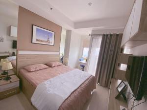 WarungmanggaApartement Springwood By LiviRooms Tangerang的酒店客房设有床和窗户。