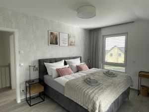 弗赖贝格ZugZuflucht-neues, modernes Ferienhaus的卧室配有一张带粉红色枕头的大床