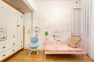 伊斯坦布尔4 Bedroom Spacious Apartment in Nisantasi的一个带粉红色婴儿床和蓝椅的幼儿园
