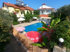 厄吕代尼兹Sarıhan Apart Otel的一座房子旁带两把遮阳伞的游泳池